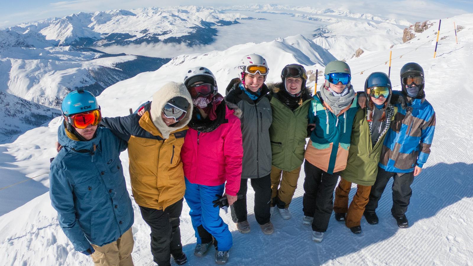 Gruppe junger Leute in Snowboardkleidung in den Bergen